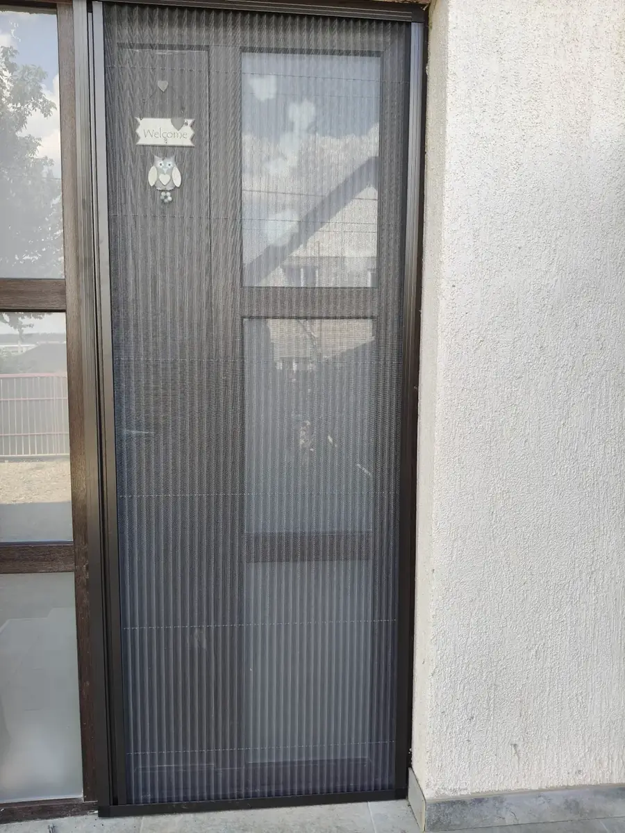 Plasă plisată tip acordeon montată pe ușă de balcon, cadru maro